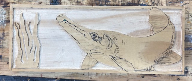 Alligator Gar drawing on wood with background carved out, creating a 3D look