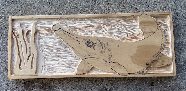 Alligator Gar on wood with water waves carved in the background